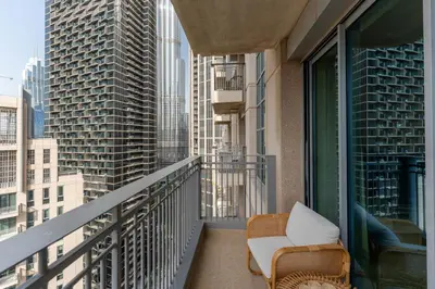 a balcony with a chair and a view of the city at Stand Point Residence by Hogar in Dubai