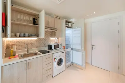 a kitchen with a sink and a washing machine at Spacious Studio Beach Access Seven Palm Dubai in Dubai