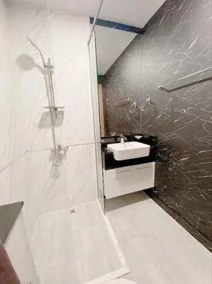 a white bathroom with a shower and a sink at Luxury 1BR Apartment with Burj Khalifa&Canal view in Dubai