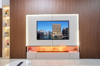 a living room with a tv on a wall with a fire place at PJ- Premium Palm Jumeirah Apartment - Beachfront, Pool & Balcony in Dubai