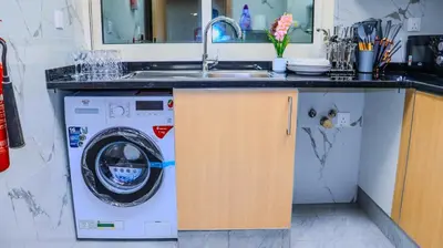 a kitchen with a sink and a washing machine at 1BHK Holiday Location in Dubai