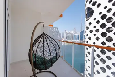 a swing on a balcony with a view of the city at 5 Min Downtown in Dubai