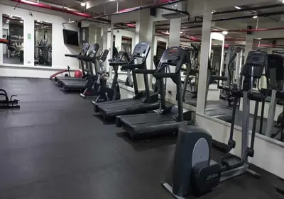 a row of tread machines in a gym at Bay Square studio Bay view in Dubai