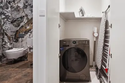 a laundry room with a washing machine and a sink at Lagoon Charm Luxurious Waterfront Living in Dubai