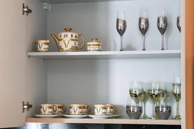 a shelf with wine glasses and a teapot at Lagoon Charm Luxurious Waterfront Living in Dubai