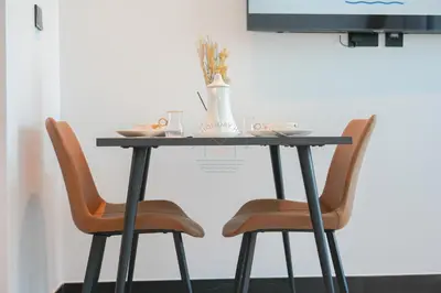 a table with two chairs and a vase on it at Stylish Retreat in Business Bay in Dubai