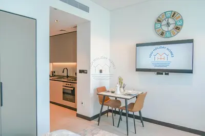 a kitchen with a table and chairs and a clock on the wall at Stylish Retreat in Business Bay in Dubai
