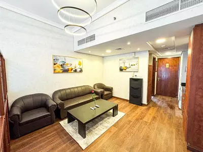 a living room with two couches and a table at Fully Furnished Studio Lake Terrace, JLT Prime Location by Al sarya Holiday Homes in Dubai