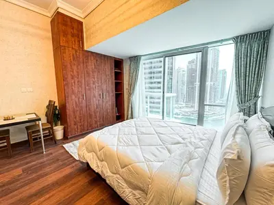 a bedroom with a bed and a window with a desk at Fully Furnished Studio Lake Terrace, JLT Prime Location by Al sarya Holiday Homes in Dubai