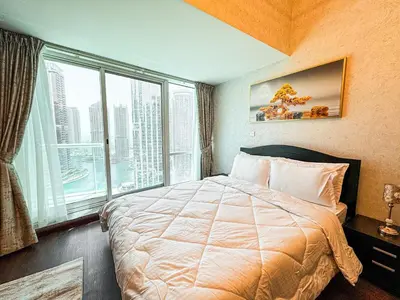 a bedroom with a large bed and a large window at Fully Furnished Studio Lake Terrace, JLT Prime Location by Al sarya Holiday Homes in Dubai