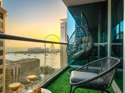 a balcony with two chairs and a table and drinks at WonderfulStay at Marine Towers - Full Ain & Marina View - JBR Grande Living - Brand New Apartments in Dubai