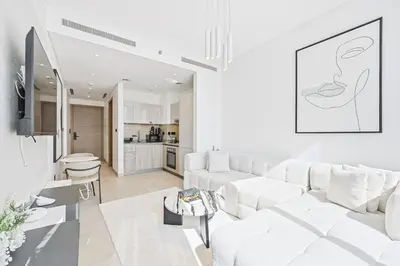 a living room with a white couch and a table at High-Floor Luxury Spacious 1BR in Sobha Waves in Dubai
