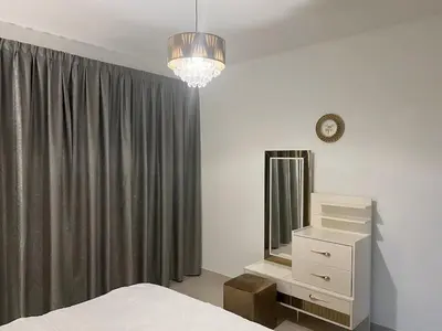 a bedroom with a bed and a mirror and a dresser at Elegant 1 Bedroom Apartment, The Lofts West Tower, Downtown Dubai By Al sarya Holiday Homes in Dubai