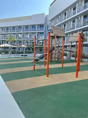 a playground in front of a large building at Cosy Studio - Luma 22 in Dubai