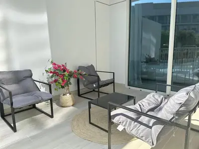 a living room with two chairs and a table at Cosy Studio - Luma 22 in Dubai