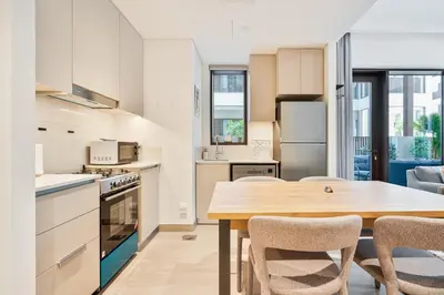 a kitchen and dining room with a table and chairs at Charming 1BR with Airy Terrace, Pool and Gym Access in Dubai