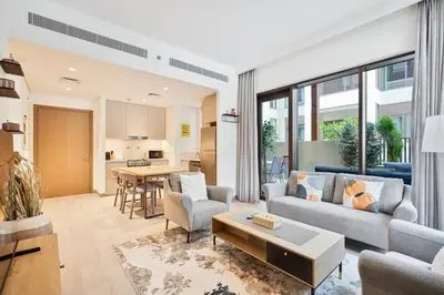 a living room with a couch and a table at Charming 1BR with Airy Terrace, Pool and Gym Access in Dubai