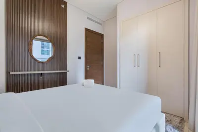 a bedroom with a white bed and a mirror at STAY BY LATINEM Luxury 1BR Holiday Home CVR B803 Near Burj Khalifa in Dubai