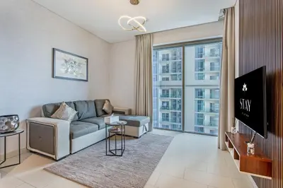 a living room with a couch and a tv at STAY BY LATINEM Luxury 1BR Holiday Home CVR B803 Near Burj Khalifa in Dubai