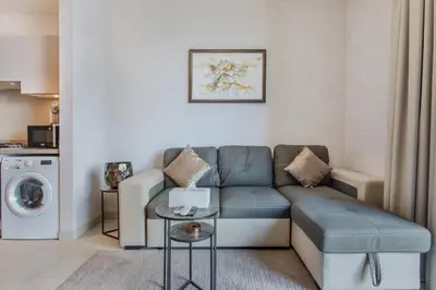 a living room with a couch and a washing machine at STAY BY LATINEM Luxury 1BR Holiday Home CVR B803 Near Burj Khalifa in Dubai
