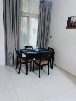 a dining room table with four chairs and a window at 3 Bedroom Villa in Vardon Cluster Damac Hills 2 Peaceful Family Retreat By al sarya Holiday Homes in Dubai