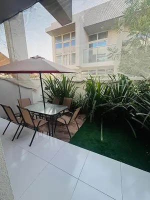 a patio with a table and chairs and an umbrella at 3 Bedroom Villa in Vardon Cluster Damac Hills 2 Peaceful Family Retreat By al sarya Holiday Homes in Dubai