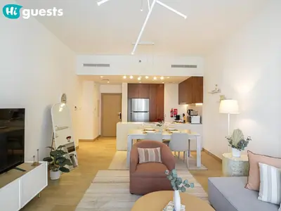 a living room with a couch and a dining room at HiGuests - Soothing Seaside 2 BR Haven in La Mer in Dubai