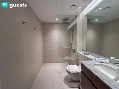 a bathroom with a toilet and a sink and a mirror at HiGuests - Soothing Seaside 2 BR Haven in La Mer in Dubai