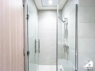 a shower with a glass door in a bathroom at Charming Studio with Balcony in Azizi Riviera in Dubai