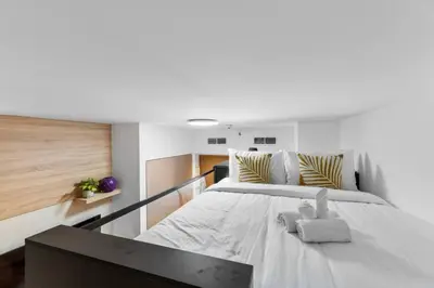 a bedroom with a large white bed with a stuffed animal on it at Miami Vibes | Canal View | Fully Furnished Studio in Dubai