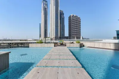 a swimming pool on the roof of a building with tall buildings at Miami Vibes | Canal View | Fully Furnished Studio in Dubai
