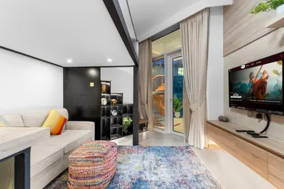 a living room with a couch and a flat screen tv at Miami Vibes | Canal View | Fully Furnished Studio in Dubai