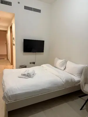 a bedroom with a bed with a tv on the wall at EGATE - Studio - 10th Floor - Balcony with a View - 01-1014 in Dubai