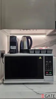 a microwave with a coffee maker on top of it at EGATE - Studio - 10th Floor - Balcony with a View - 01-1014 in Dubai