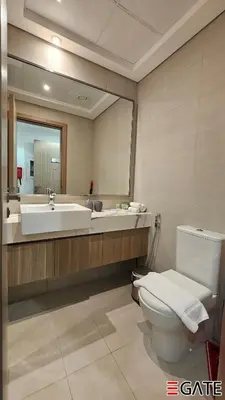 a bathroom with a toilet and a sink and a mirror at EGATE - Studio - 10th Floor - Balcony with a View - 01-1014 in Dubai