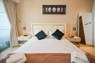 a bedroom with a large white bed with green pillows at Luxe 2BR with Fountain Views and Walk-Around Terrace in Dubai