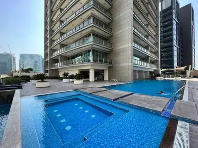 a swimming pool in front of a building at Luxe 2BR with Fountain Views and Walk-Around Terrace in Dubai