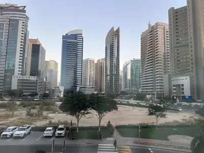 a city skyline with cars parked in a parking lot at Cozy Studio Apartment in Dubai