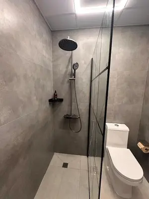 a bathroom with a shower and a toilet at Cozy Studio Apartment in Dubai