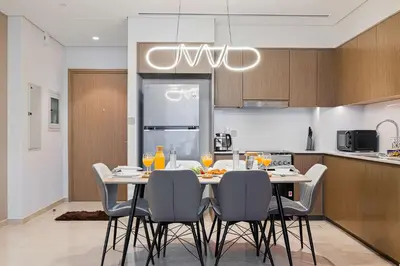 a kitchen with a table and chairs in a kitchen at Luxury Grande Suites by Hostiva - Full Burj Khalifa View in Dubai