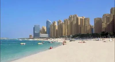 a beach with people in the water and buildings at Luxury Casa - Marina Diamond 2 in Dubai