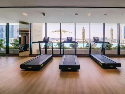 a gym with two beds in a room with windows at Trillionaire Business Bay with Private Jacuzzi in Dubai