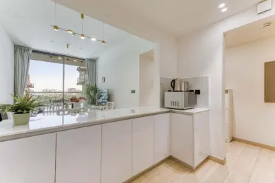 a kitchen with white cabinets and a microwave at PVH - Cosy 2BR Plus Study - Binghatti Crescent in Dubai