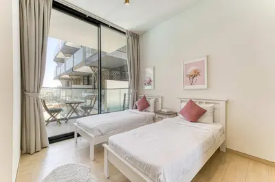 a bedroom with two beds and a balcony at PVH - Cosy 2BR Plus Study - Binghatti Crescent in Dubai