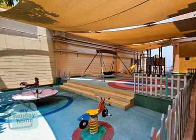 a childrens play area with a pool and swings at Steps to Beach - Resort Residence - Palm Jumeirah in Dubai