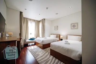 a hotel room with two beds and a television at Steps to Beach - Resort Residence - Palm Jumeirah in Dubai