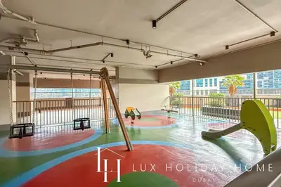 a play area with two swings and a slide at LUX The Burj Khalifa Downtown View Studio 2 in Dubai