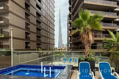 a swimming pool on the roof of a building with a palm tree at LUX The Burj Khalifa Downtown View Studio 2 in Dubai