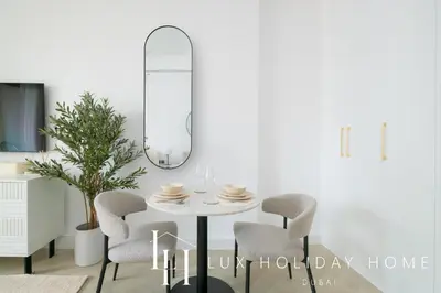 a dining room with a white table and chairs at LUX The Burj Khalifa Downtown View Studio 2 in Dubai