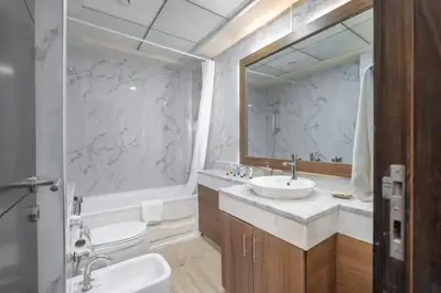 a bathroom with a sink and a toilet and a mirror at Vogue Marina Torch Tower near JBR Beach and Dubai Marina Mall, Two Bedroom Apartment with Balcony and City Skyline View, Access to all Amenities in Dubai